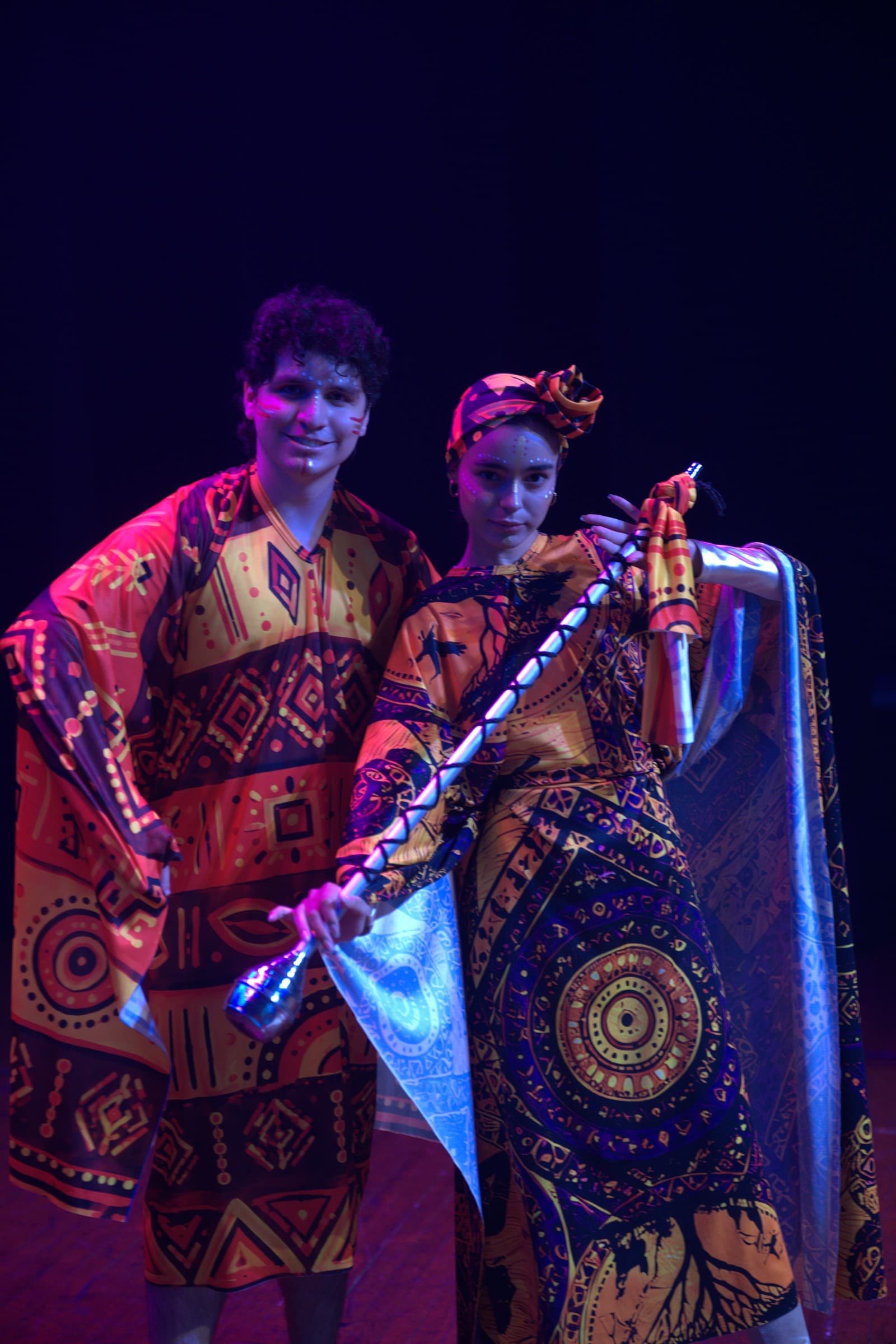 Dos bailarines con vestuario de estampados africanos y maquillaje escénico