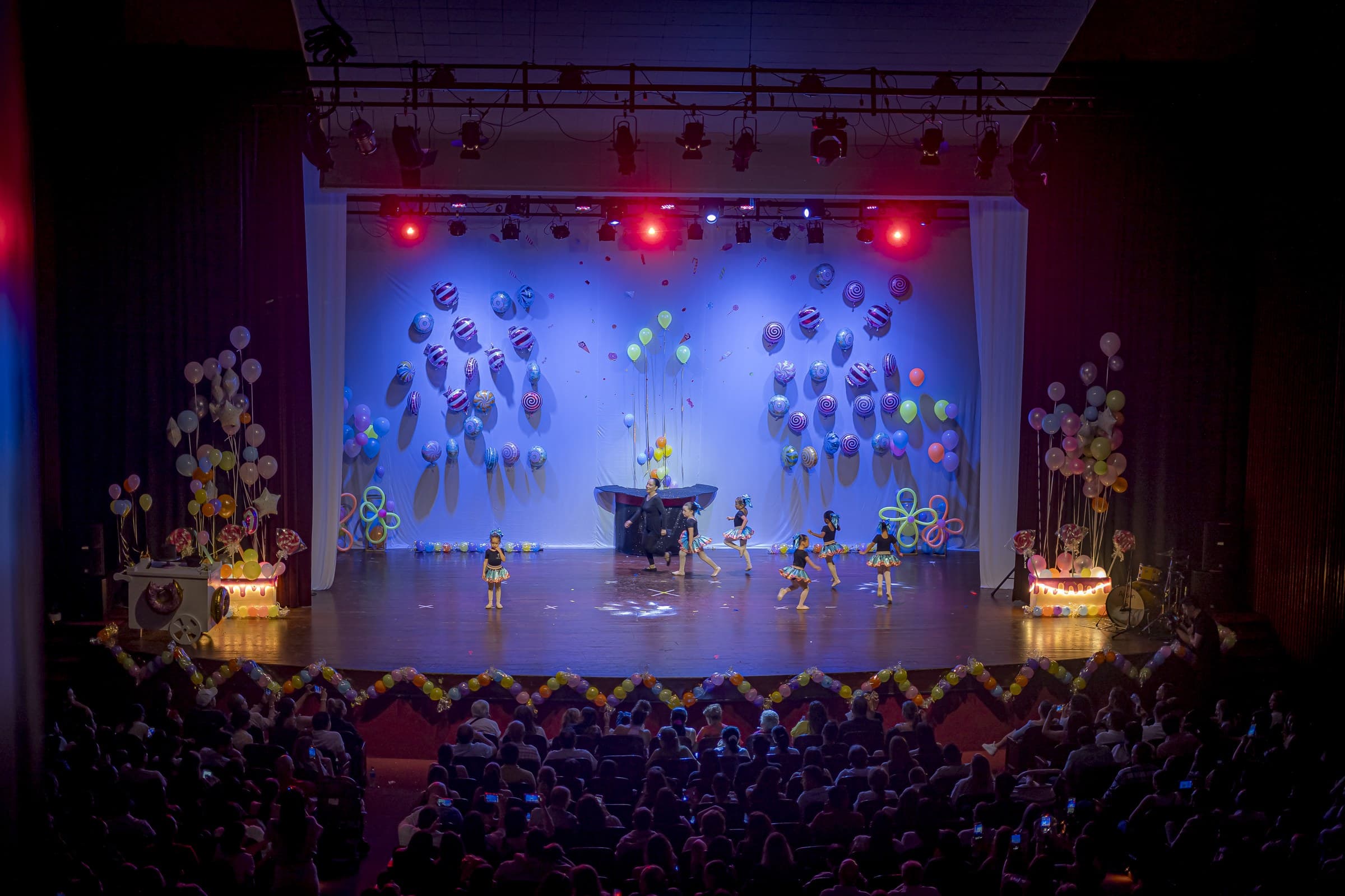 Vista general del escenario decorado con globos de dulces, con el público al frente